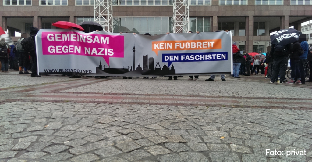 Foto zeigt: Menschen mit Banner 'Kein Fußbreit den Faschisten - Gemeinsam gegen Nazis' vor dem Rathaus